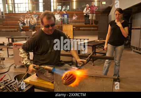 Besucher in der öffentlichen Beobachtungsgalerie beobachten Glaskünstler bei der Arbeit in der Canberra Glashütte Stockfoto