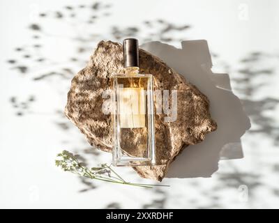 Mockup geometrische Form Stein Podium mit Glas Parfüm Flasche Draufsicht. Steinform mit Gypsophila-Blüten Schattierungen auf weißem Hintergrund. Flach liegend. Kann als Parfüm und kosmetische Nachbau verwenden Stockfoto