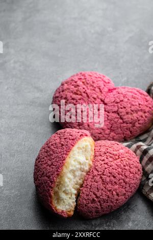 Herzförmige Choux-Kekse mit Cremefüllung auf grauem Hintergrund Stockfoto