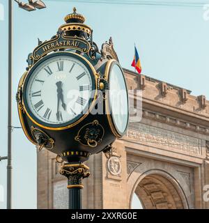 Bukarest, Rumänien, 17. Juli 2024, Triunfical Arch historische Stadtuhr. Rumänische Flagge. Stockfoto