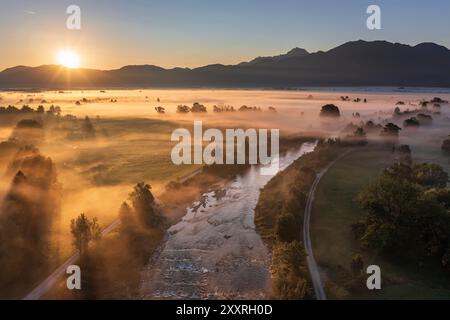 Luftaufnahme eines Flusses vor den Bergen bei Sonnenaufgang mit Nebel, Fluss Loisach, Loisach Kochelsee Moor, Bayern, Deutschland, Europa Stockfoto