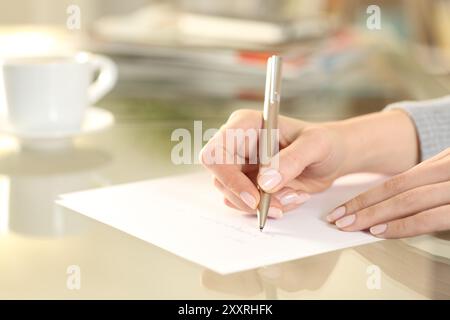 Nahaufnahme einer Frau, die zu Hause auf Papier schreibt Stockfoto