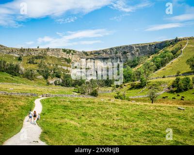 2. August 2024: Malham Cove, North Yorkshire, Vereinigtes Königreich - Eine Familie, die auf dem Fußweg in Richtung Malham Cove im Yorkshire Dales National Park spaziert Stockfoto