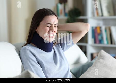 Rekonvaleszierende Frau leidet allein zu Hause Nackenschmerzen Stockfoto