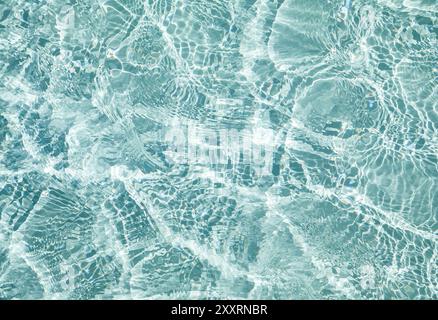 Blaues transparentes Wasser mit Flecken von Sonnenschein, abstrakter Hintergrund Stockfoto