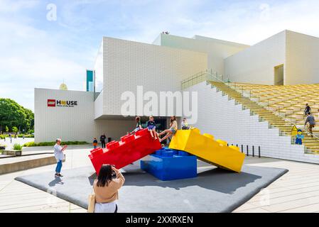 Kinder posieren auf riesigen Lego-Ziegeln am Haupteingang des Lego House, Heimat der Ziegelsteine, in Billund, Dänemark. Stockfoto