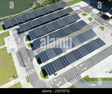 Blick aus der Vogelperspektive über innovativen Solarpaneelen auf den Dächern eines Parkplatzes Stockfoto