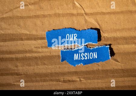 Unsere Botschaft steht auf gerissenen blauen Papierstücken mit Papphintergrund. Konzeptionelles unser Missionssymbol. Kopierbereich. Stockfoto