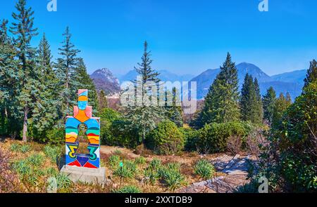 CARONA, SCHWEIZ - 22. MÄRZ 2022: Panorama des Parco San grato mit moderner Skulptur Umanita e ambiente von Marino Gambusi, Carona, Schweiz Stockfoto