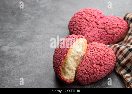 Herzförmige Choux-Kekse mit Cremefüllung auf grauem Hintergrund Stockfoto