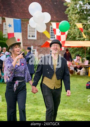 Muddles Green, Großbritannien. August 2024. Die Gäste des jährlichen Surrealismus-Picknicks in den Gärten des Farleys House ehren die Geschichte dieser faszinierenden Kunstbewegung aus dem 20. Jahrhundert im Sartorial-Stil. Das Farleys House, das in der Familie Penrose verbleibt, war einst Heimat des Surrealismus-Fotografen Lee Miller und ihres Künstlerhauses Roland Penrose, ein Treffpunkt für viele bekannte Künstler der Bewegung, darunter Pablo Picasso, Max Ernst, Joan Miró und man Ray. Farley Farm feiert in diesem Jahr sein 75-jähriges Bestehen als Heimstadion der Surrealisten. Quelle: Jim Holden/Alamy Live News Stockfoto