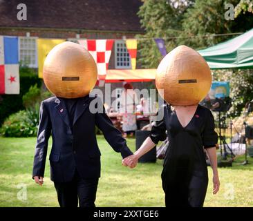 Muddles Green, Großbritannien. August 2024. Die Gäste des jährlichen Surrealismus-Picknicks in den Gärten des Farleys House ehren die Geschichte dieser faszinierenden Kunstbewegung aus dem 20. Jahrhundert im Sartorial-Stil. Das Farleys House, das in der Familie Penrose verbleibt, war einst Heimat des Surrealismus-Fotografen Lee Miller und ihres Künstlerhauses Roland Penrose, ein Treffpunkt für viele bekannte Künstler der Bewegung, darunter Pablo Picasso, Max Ernst, Joan Miró und man Ray. Farley Farm feiert in diesem Jahr sein 75-jähriges Bestehen als Heimstadion der Surrealisten. Quelle: Jim Holden/Alamy Live News Stockfoto