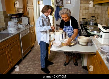 Großmutter und Enkelin machen gemeinsam Kuchen für das jährliche fest im August. In der Küche zuhause die Zutaten vor dem Backen zubereiten. Eastleach Turville, Gloucestershire England 1993 1990er Jahre Großbritannien HOMER SYKES Stockfoto