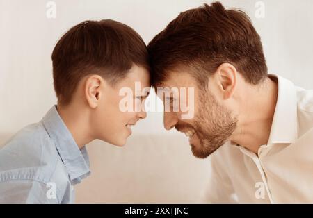 Gerne Vater und Sohn beugen Kopf berühren Stirnen, weißer Hintergrund Stockfoto