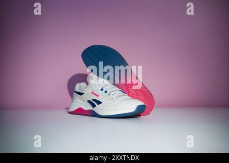 Straßburg, Frankreich - August 2024 : neue Trainingsschuhe Reebok Nano X4 auf rosa und weißem Hintergrund Seite und Sohle. Stylische, lebendige Schuhe für aktive Menschen Stockfoto