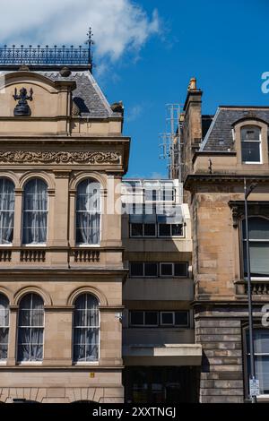 EDINBURGH - 28. JULI 2024: Kontrast zwischen historischen und modernen Gebäuden in Edinburgh zeigt architektonische Vielfalt unter einem klaren blauen Himmel. Stockfoto