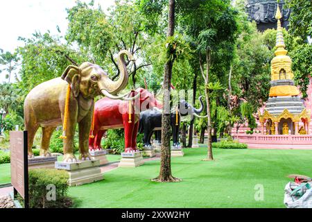 Bangkok, Samut Prakan, Thailand, Südostasien, Asien. Erawan Museum. Glückliche Elefantenstatuen im Museumsgarten, im Hintergrund Phra Ket Chulama Stockfoto