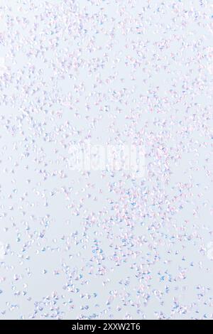 Kleines silbernes Kristallkonfetti auf blauem Hintergrund. Glitzernde Textur. Stockfoto