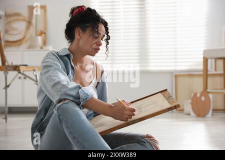 Schöne Frau, die im Studio Porträt mit Bleistift zeichnet Stockfoto