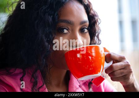 Eine stilvolle afroamerikanische Frau aus Nahaufnahme, die Kaffee im Café trinkt Stockfoto