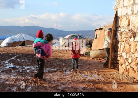 Syrische Flüchtlinge im Lager Kamuna für Binnenvertriebene sind mit rauem Wetter konfrontiert. Das Lager befindet sich in der Provinz Idlib, westlich von Aleppo und nahe der türkischen Grenze. Infolge der jüngsten Intensivierung der Luftangriffe im Land sind mehr Syrer aus ihrer Heimat und ihren Städten geflohen. In dem Versuch, Zuflucht vor den Streiks zu finden, haben auch einige Syrer begonnen, in Höhlen zu leben. Seit Ausbruch des syrischen Krieges im März 2011 sind nach Schätzungen der UNO 11 Millionen Syrer aus ihrer Heimat geflohen, von denen 6,6 Millionen innerhalb Syriens vertrieben werden Stockfoto