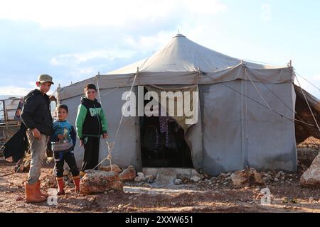 Syrische Flüchtlinge im Lager Kamuna für Binnenvertriebene sind mit rauem Wetter konfrontiert. Das Lager befindet sich in der Provinz Idlib, westlich von Aleppo und nahe der türkischen Grenze. Infolge der jüngsten Intensivierung der Luftangriffe im Land sind mehr Syrer aus ihrer Heimat und ihren Städten geflohen. In dem Versuch, Zuflucht vor den Streiks zu finden, haben auch einige Syrer begonnen, in Höhlen zu leben. Seit Ausbruch des syrischen Krieges im März 2011 sind nach Schätzungen der UNO 11 Millionen Syrer aus ihrer Heimat geflohen, von denen 6,6 Millionen innerhalb Syriens vertrieben werden Stockfoto