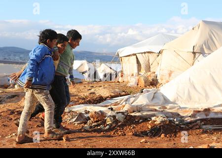 Syrische Flüchtlinge im Lager Kamuna für Binnenvertriebene sind mit rauem Wetter konfrontiert. Das Lager befindet sich in der Provinz Idlib, westlich von Aleppo und nahe der türkischen Grenze. Infolge der jüngsten Intensivierung der Luftangriffe im Land sind mehr Syrer aus ihrer Heimat und ihren Städten geflohen. In dem Versuch, Zuflucht vor den Streiks zu finden, haben auch einige Syrer begonnen, in Höhlen zu leben. Seit Ausbruch des syrischen Krieges im März 2011 sind nach Schätzungen der UNO 11 Millionen Syrer aus ihrer Heimat geflohen, von denen 6,6 Millionen innerhalb Syriens vertrieben werden Stockfoto