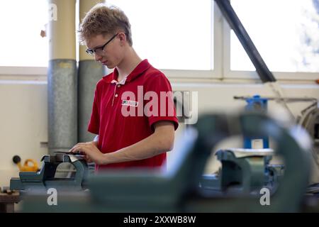 Ranstadt, Deutschland. August 2024. Max Blasnik, Mechatroniker-Lehrling, übt in der Ausbildungswerkstatt der Hassia Verpackungsmaschinen GmbH. Der Maschinenbauspezialist baut Umformmaschinen, Füll- und Dichtmaschinen und sucht Nachwuchstalente. Quelle: Christian Lademann/dpa/Alamy Live News Stockfoto