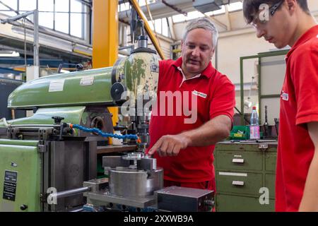 Ranstadt, Deutschland. August 2024. Jonas helle (r), ausgebildeter Bediener von Schneidemaschinen, erhält bei der Hassia Verpackungsmaschinen GmbH von Trainer Christian Seum, ebenfalls Teamleiter Produktion, Einweisung in eine konventionelle Fräsmaschine. Der Maschinenbauspezialist baut Umformmaschinen, Füll- und Dichtmaschinen und sucht Nachwuchstalente. Quelle: Christian Lademann/dpa/Alamy Live News Stockfoto