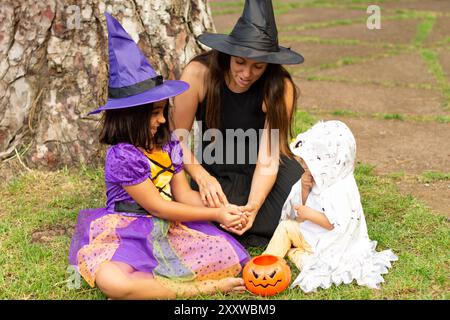 Familie in halloween Kostüm feiert und isst Süßigkeiten Stockfoto