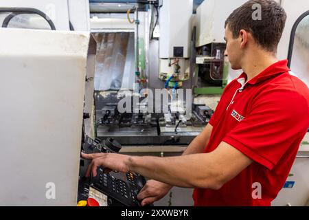 Ranstadt, Deutschland. August 2024. Jonas Adrian, ein ausgebildeter Industriemechaniker, baut bei der Hassia Verpackungsmaschinen GmbH eine CNC-Fräsmaschine auf. Das spezialisierte Maschinenbauunternehmen baut Formen-, Füll- und Dichtmaschinen und sucht Nachwuchstalente. Quelle: Christian Lademann/dpa/Alamy Live News Stockfoto