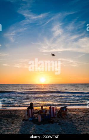 Die Familie а beobachtet den Sonnenuntergang an einem Strand in Venedig, Florida Stockfoto