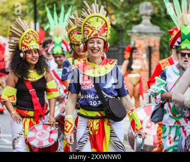 London, Großbritannien. August 2024. Die Teilnehmer der Paraiso School of Samba, einer der größten Gruppen mit fast 200 Künstlern und Musikern, kommen vom frühen Morgen bis zum Beginn der Prozession um 12 Uhr. Am Montag findet der Karnevalszug von MAS-Bands, Schlagzeugern und karibischen und südamerikanischen Salsa-, Samba- und Soca-Gruppen statt. Am zweiten von zwei Tagen des Karnevalsfestes in Notting Hill feiern die Nachtschwärmer das Wochenende der Bank Holiday, an den Soundsystemen, an den Ständen und an den Veranstaltungsorten entlang der Karnevalsroute. Quelle: Imageplotter/Alamy Live News Stockfoto