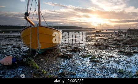 Boot ruht bei Ebbe auf dem Boden in Findhorn Bay, Scottish Highlands, bei Sonnenuntergang. Stockfoto