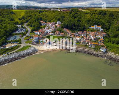 Das Küstendorf Runswick Bay in North Yorkshire wird von oben erfasst und zeigt seine bezaubernden Häuser, den Strand und die umliegenden üppigen Landschaften Stockfoto