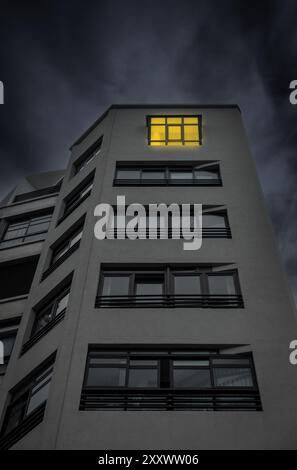 Licht an im Fenster der Wohnung in einem hohen Gebäude. Stockfoto