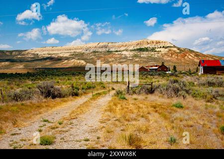 Vor dem Fossil Butte National Monument in Wyoming steht ein raues ländliches Gebäude, dessen verwitterte Struktur sich von der Ma des Monuments abhebt Stockfoto