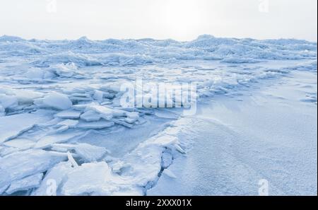 Landschaft mit gebrochenen Eissplittern, die an einem sonnigen Wintertag an der Ostseeküste liegen. Eisbuckel Stockfoto