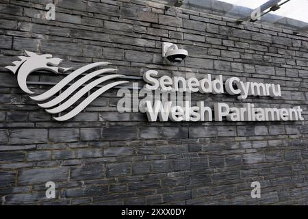 Sein Senedd Cymru - walisisches Parlamentsschild an der Vorderseite des Senedd Building, Cardiff Bay. Aufgenommen 2024 Stockfoto