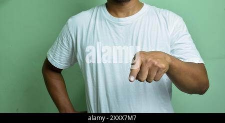 Männliche Hand zeigt unten isoliert auf grünem Hintergrund Stockfoto