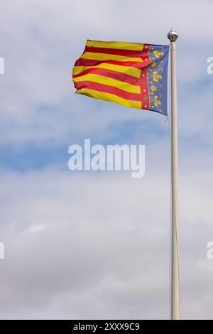 Foto der Flagge der Valencianischen Gemeinschaft, die an einem klaren Tag im Wind winkt. Die Valencianische Gemeinschaft ist eine autonome Gemeinschaft Spaniens Stockfoto