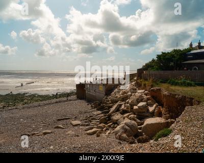 Seaford - Eastbourne - Großbritannien - 2024.08.25: Idyllische Küstenhäuser überblicken majestätische weiße Klippen vor einem hellblauen Himmel. Ein ruhiger Küstenabschnitt Stockfoto