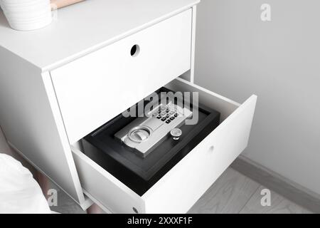 Offene Schublade mit modernem Safe im Schlafzimmer, Nahaufnahme Stockfoto