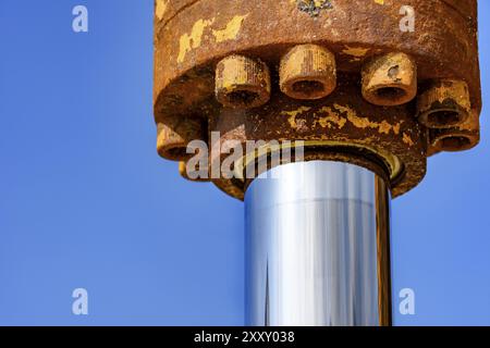 Detail der hydraulischen Zahnrad mit Rost auf einen Traktor, der mit einem blauen Himmel im Hintergrund Stockfoto