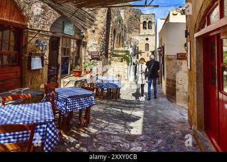 Monemvasia, Griechenland, 31. März 2019: Blick auf die Straße mit alten Häusern und griechischer Restaurant-Taverne in der antiken Stadt Peloponnes, Europa Stockfoto