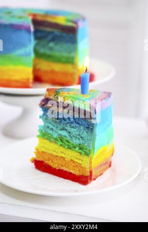 Regenbogen Kuchen verziert mit Geburtstag Kerze. Nahaufnahme Stockfoto