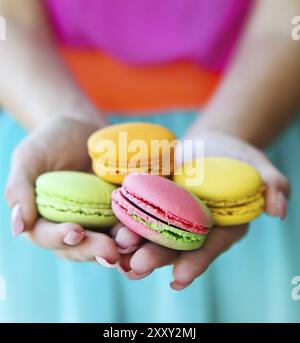 Mädchen in Händen hält, bunte französische Macarons Stockfoto