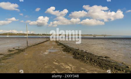 Boote in der OARE Sümpfen mit der Insel Sheppey im Hintergrund, in der Nähe von Faversham, Kent, England, Großbritannien Stockfoto