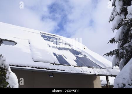 Schneebedeckte Sonnensysteme. Schneebedeckt, Modul. Sonnensystem im Winter mit Schnee auf dem Dach Stockfoto