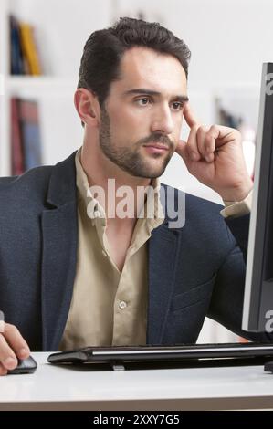 Mann auf einem Computerbildschirm Nachdenken über die Arbeit an der hand Stockfoto